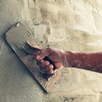 construction worker plastering cement on wall